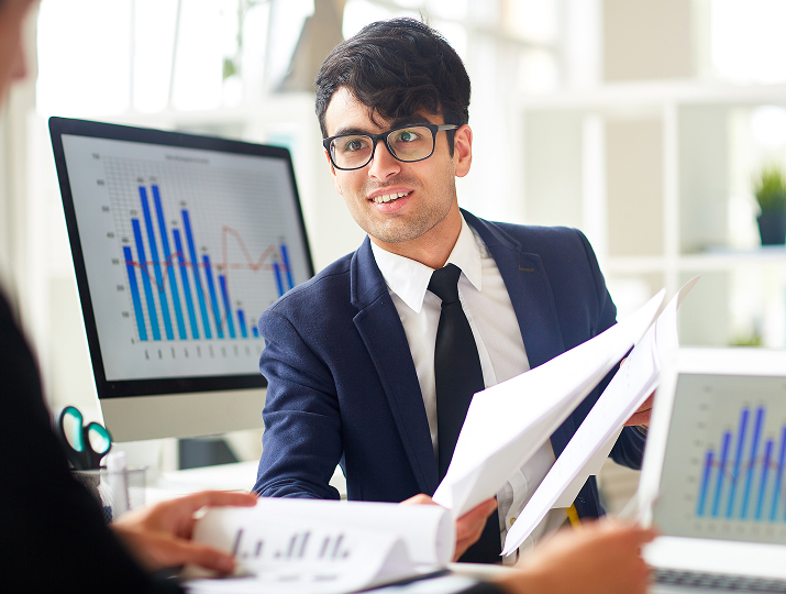 Fractional CFO reviewing financial reports with a client in an office setting